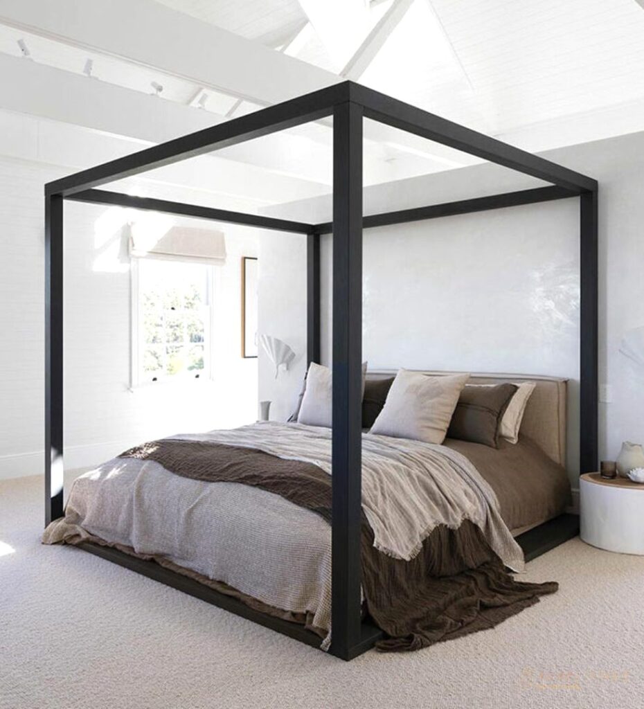 Black canopy bed in a bright white master bedroom