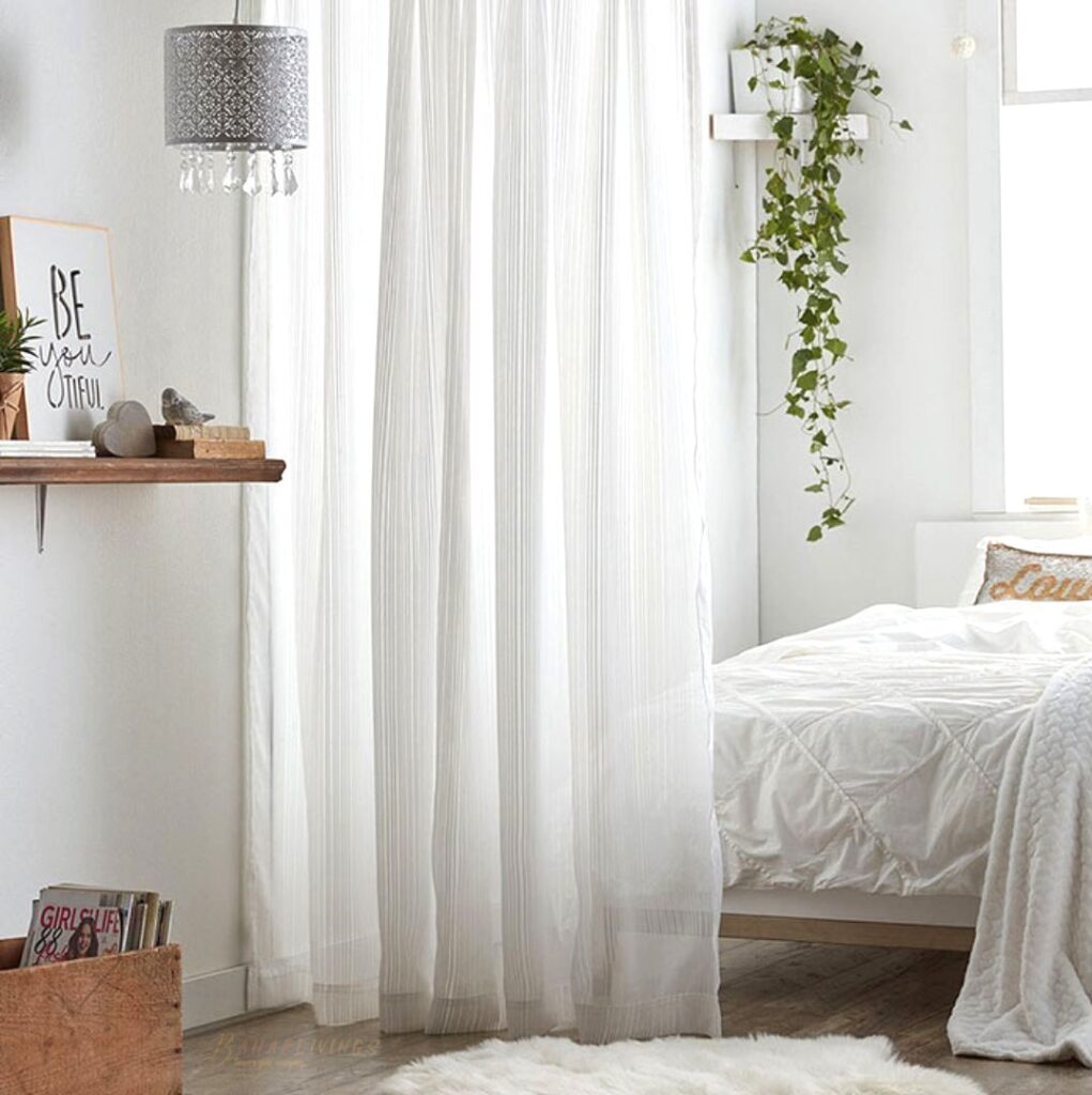 White bright bedroom with room divider as a curtain